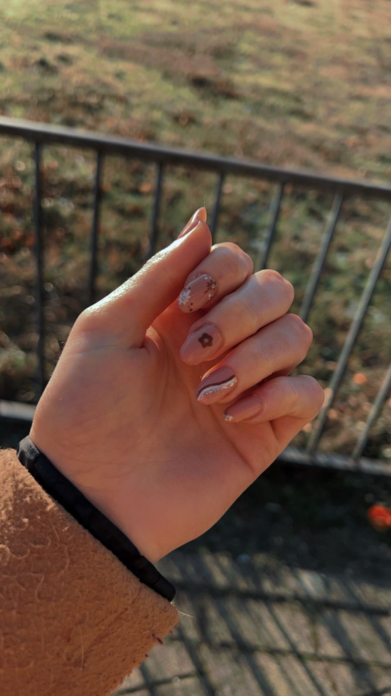 Nagels met nail art, een hand boven een hek