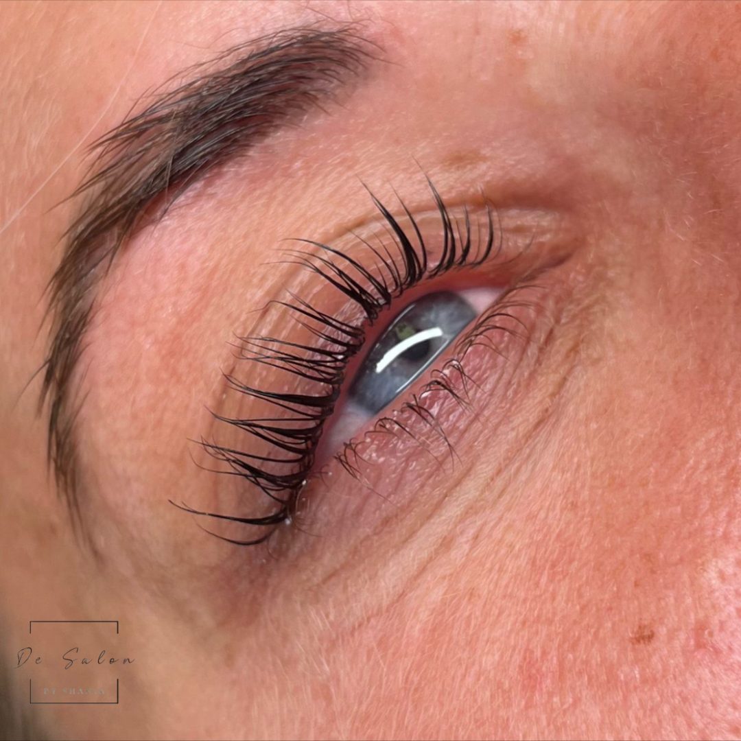 Close-up van een set wimpers met het logo van De Salon by Shania