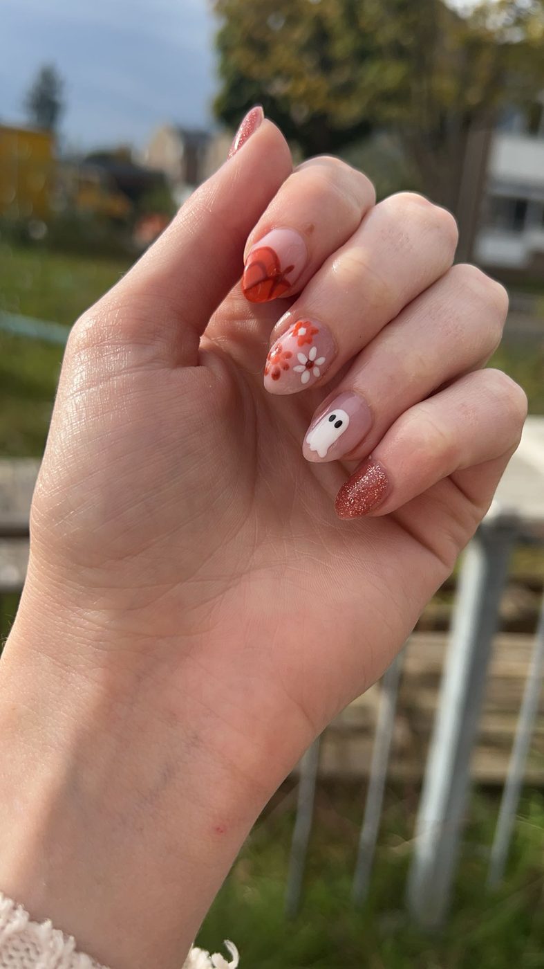 Nagels met herfstige nail art, buiten gefotografeerd