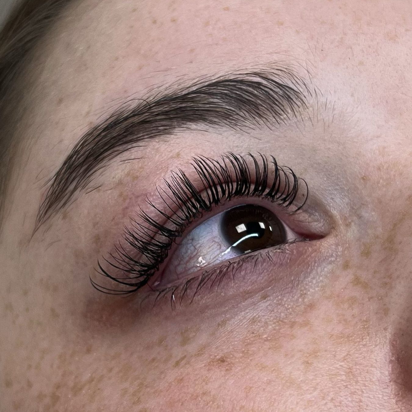 Wimperextensions bij een bruin oog met een strakke wenkbrauw